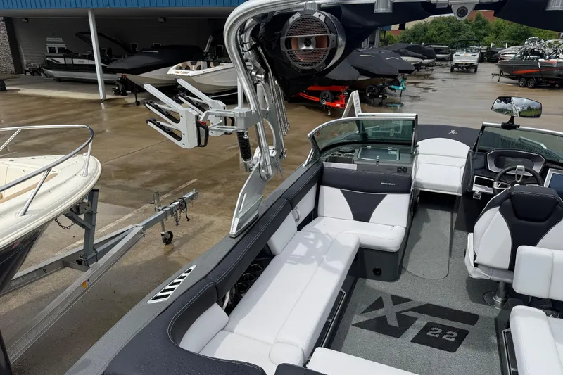 Slide: The Image of 2021 MasterCraft XT22 boat interior with seating and control panel, displayed at a dealership. - 32