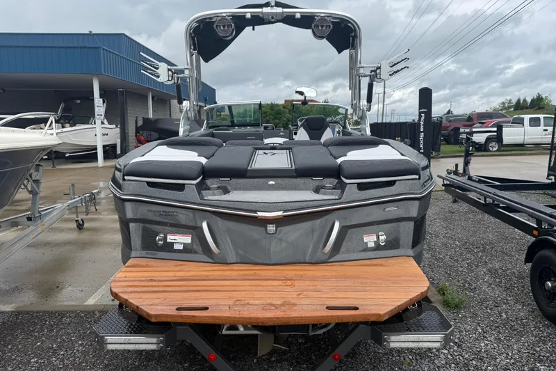 Slide: The Image of 2021 MasterCraft XT22 boat with sleek design, parked outdoors on a cloudy day. - 36