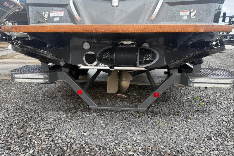 Slide: The Image of Rear view of a 2021 MasterCraft XT22 boat on a gravel surface. - 37