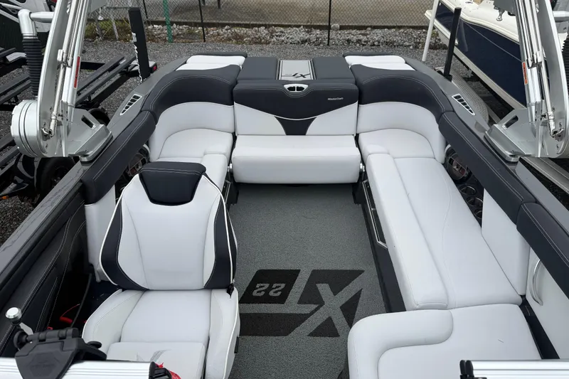 Slide: The Image of 2021 MasterCraft XT22 boat interior with sleek white and black seating design. - 9