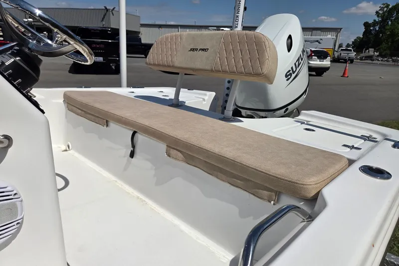 Slide: The Image of 2024 Sea Pro 172 Bay boat interior with beige seating and Suzuki outboard motor. - 10