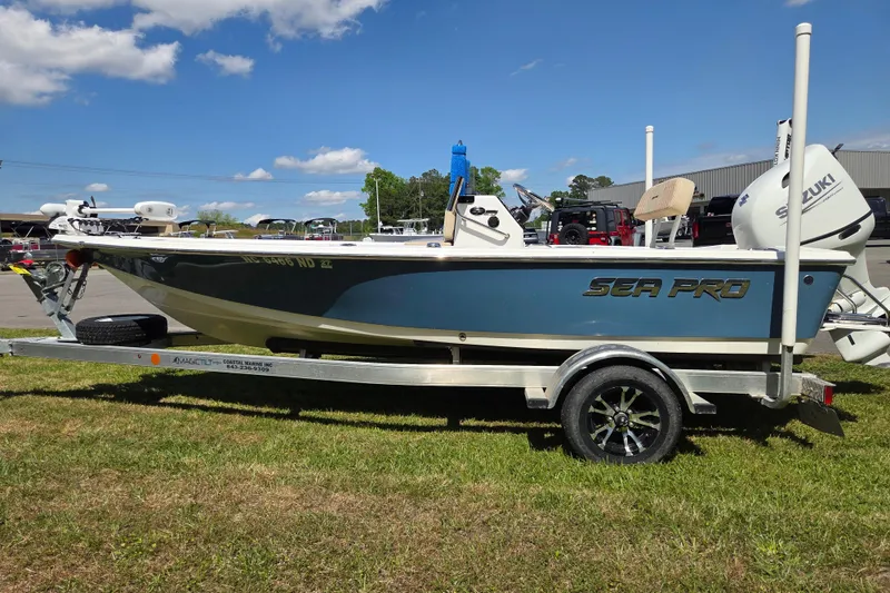 Slide: The Image of 2024 Sea Pro 172 Bay boat on trailer, parked outdoors under a clear blue sky. - 6