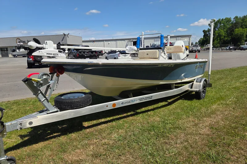 Slide: The Image of 2024 Sea Pro 172 Bay boat on trailer, parked on grass under clear blue sky. - 7