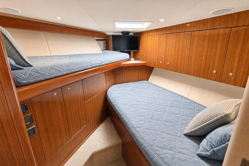 Slide: The Image of Luxurious cabin interior of 2008 Viking 52 Sport Coupe with wooden cabinetry and blue bedding. - 16