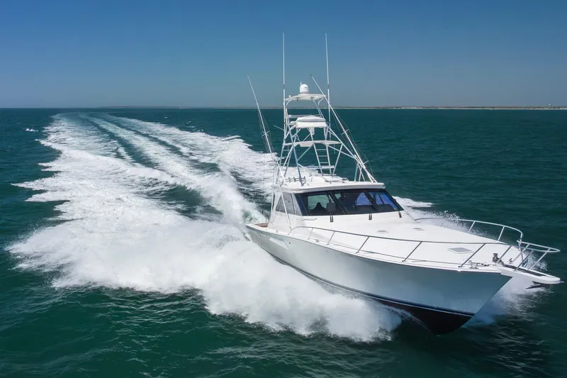 Slide: The Image of 2008 Viking 52 Sport Coupe yacht cruising on open water, leaving a wake behind. - 4