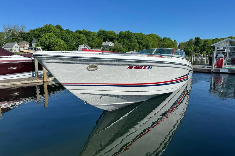 Slide: The Image of 2003 Formula 353 FASTech boat docked on calm water, surrounded by lush greenery. - 2