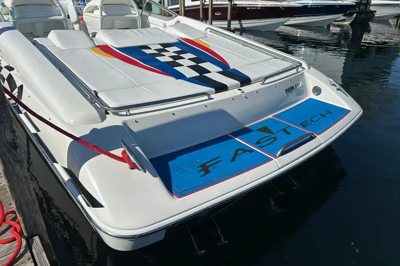Slide: The Image of 2003 Formula 353 FASTech boat docked, featuring colorful deck design and sleek white finish. - 5