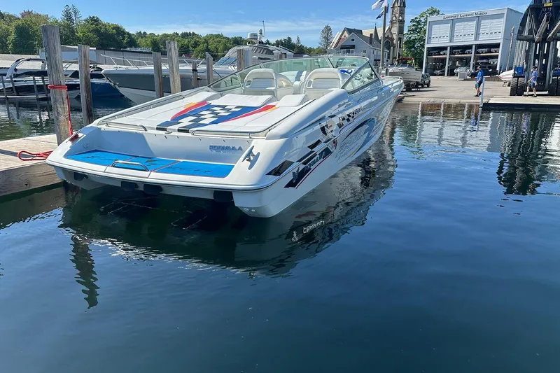 Slide: The Image of 2003 Formula 353 FASTech speedboat docked at a marina, reflecting on calm water. - 6