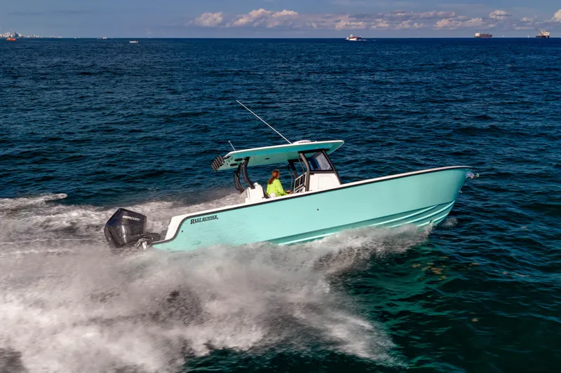 The Image of 2026 Reef Runner 340 boat cruising swiftly on open ocean waters. - 0
