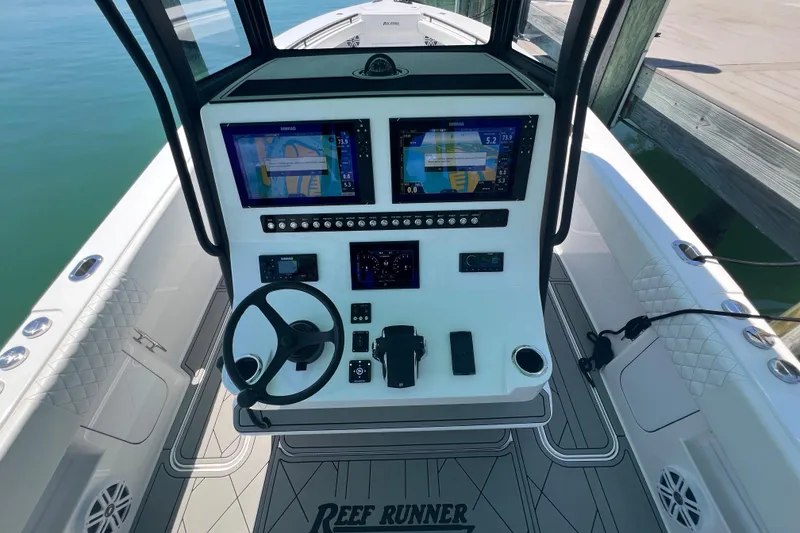 Slide: The Image of 2026 Reef Runner 340 boat dashboard with advanced navigation displays and controls. - 11