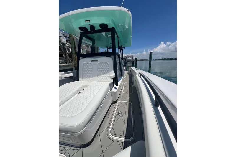 Slide: The Image of 2026 Reef Runner 340 boat with sleek design and luxurious seating, docked by calm waters. - 14