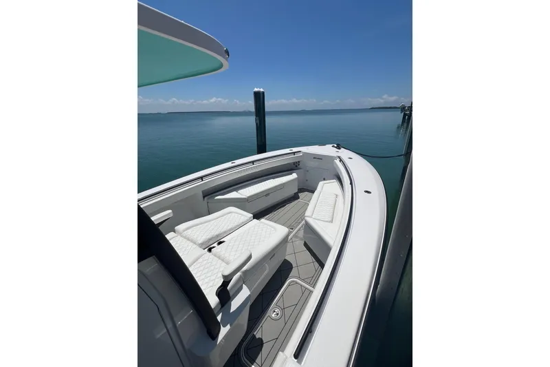 Slide: The Image of 2026 Reef Runner 340 boat with luxurious seating, docked on calm waters under a clear sky. - 16