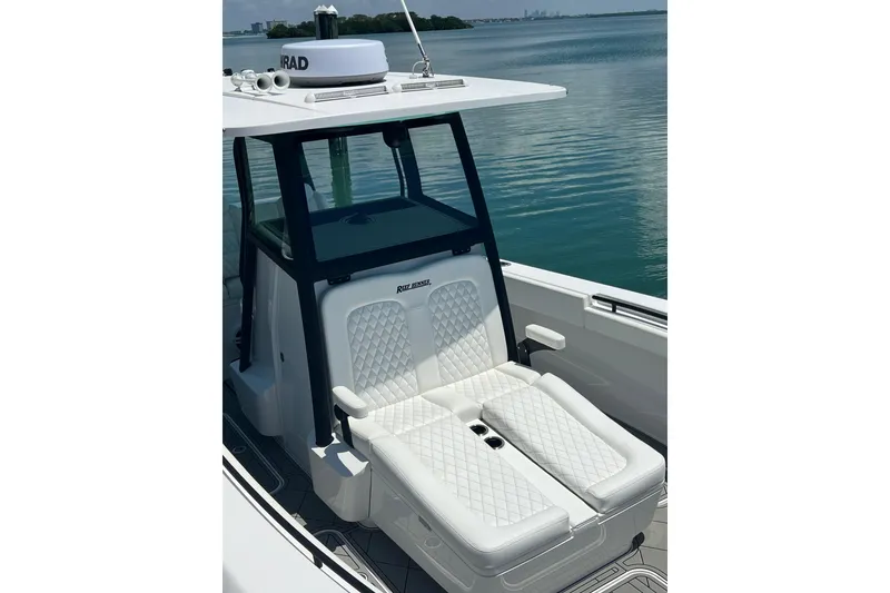 Slide: The Image of 2026 Reef Runner 340 boat with luxurious white seating on calm water. - 17