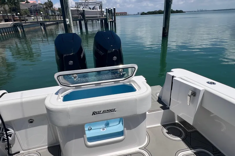 Slide: The Image of 2026 Reef Runner 340 boat with dual engines docked on calm water. - 7