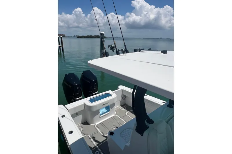 Slide: The Image of 2026 Reef Runner 340 boat with dual engines on calm water under a cloudy sky. - 8