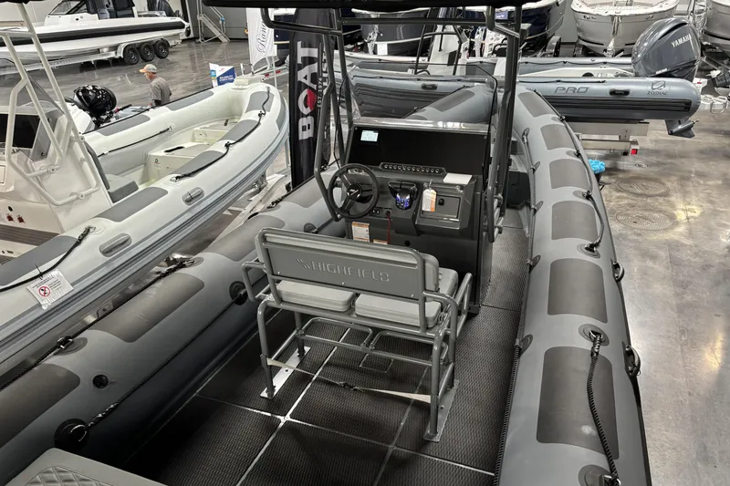 Slide: The Image of 2026 Highfield Patrol 760 boat interior at a showroom, featuring modern controls and seating. - 11
