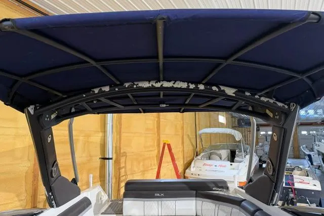 Slide: The Image of 2016 Sea Ray SLX 280 boat interior with blue canopy and seating. - 13