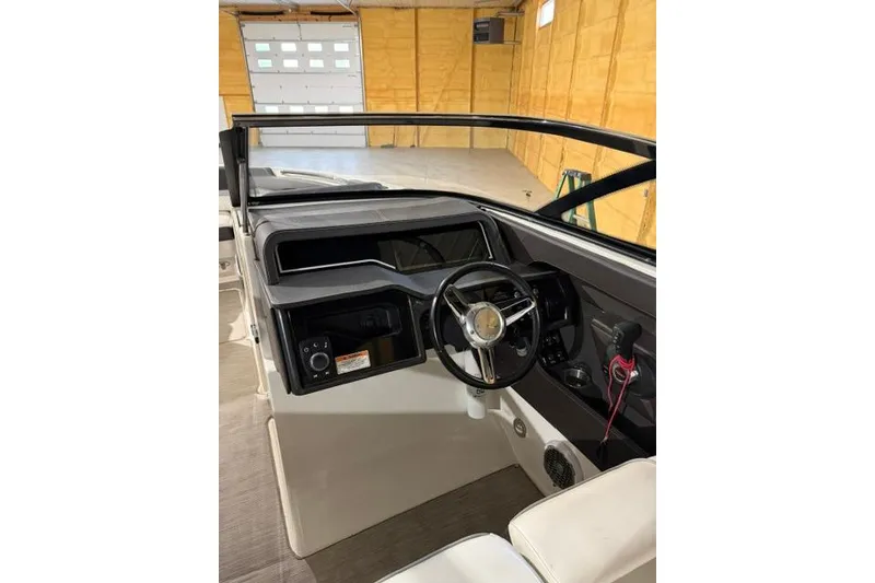 Slide: The Image of 2016 Sea Ray SLX 280 boat interior with steering wheel and dashboard in a garage. - 3