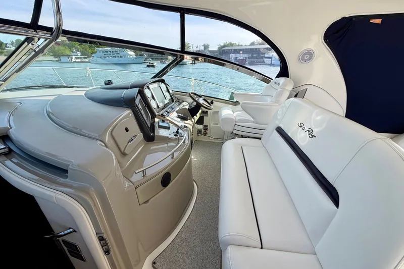 Slide: The Image of 2008 Sea Ray 44 Sundancer yacht interior with helm and seating area, overlooking marina. - 13
