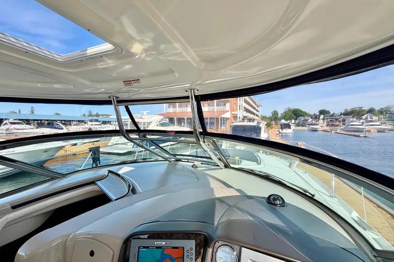 Slide: The Image of 2008 Sea Ray 44 Sundancer helm view with marina backdrop and navigation display. - 19