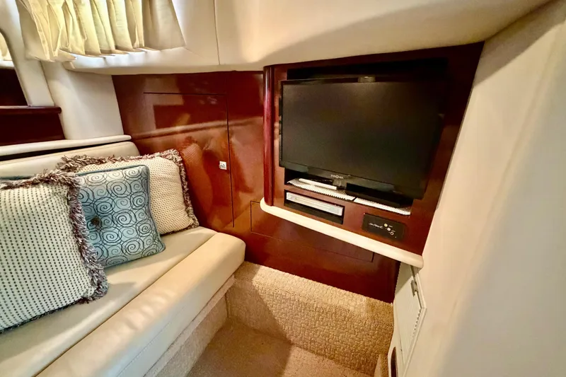 Slide: The Image of Interior of 2008 Sea Ray 44 Sundancer with TV, plush seating, and decorative pillows. - 36