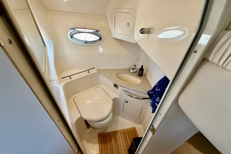 Slide: The Image of 2008 Sea Ray 44 Sundancer bathroom with compact design, featuring a toilet, sink, and porthole window. - 37