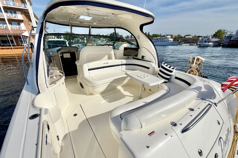 Slide: The Image of 2008 Sea Ray 44 Sundancer yacht interior with seating and table, docked by waterfront. - 4