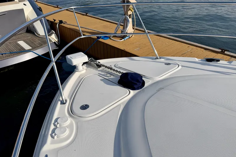 Slide: The Image of 2008 Sea Ray 44 Sundancer yacht bow with anchor chain, docked by wooden pier. - 47