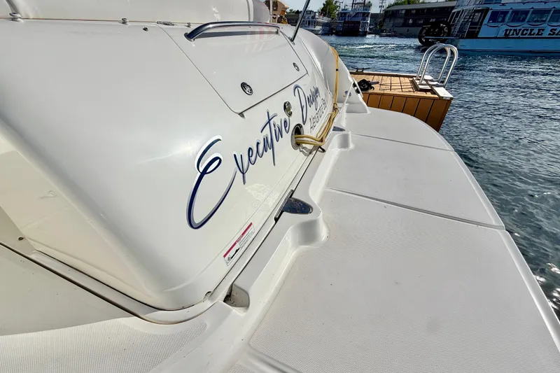 Slide: The Image of 2008 Sea Ray 44 Sundancer yacht docked, featuring "Executive Decision" name on the stern. - 56