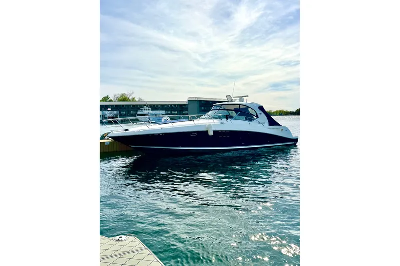 Slide: The Image of 2008 Sea Ray 44 Sundancer yacht docked on calm water under a partly cloudy sky. - 57