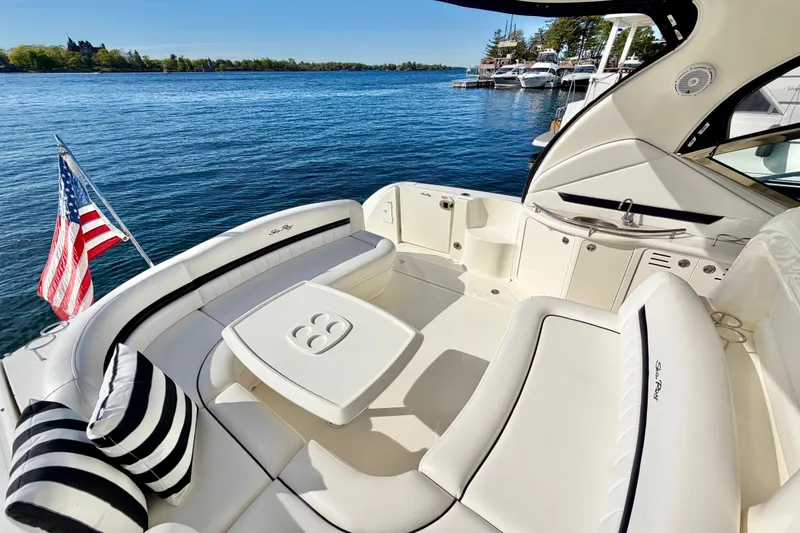 Slide: The Image of 2008 Sea Ray 44 Sundancer yacht with elegant seating and American flag on a serene lake. - 7