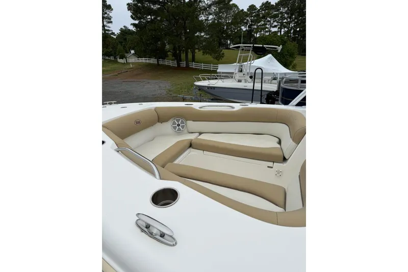 Slide: The Image of 2018 Key West 239 DFS boat with tan seating and cup holders, docked outdoors. - 7