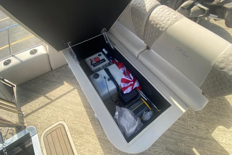 Slide: The Image of Storage compartment in 2023 JC Swingback 27 TT Sport boat, featuring safety equipment and accessories. - 10