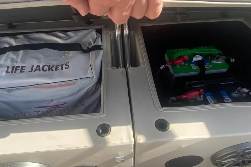 Slide: The Image of Storage compartments on a 2023 JC Swingback 27 TT Sport, containing life jackets and batteries. - 14