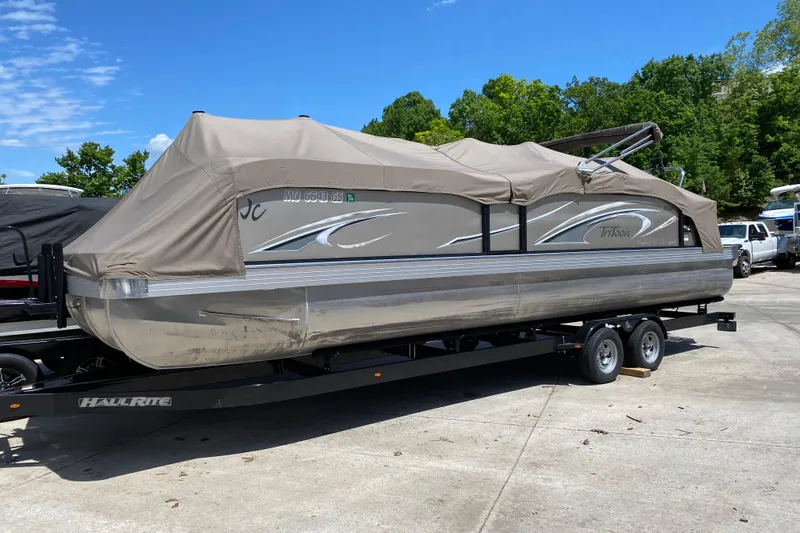 Slide: The Image of 2023 JC Swingback 27 TT Sport pontoon boat covered on trailer, parked outdoors. - 8