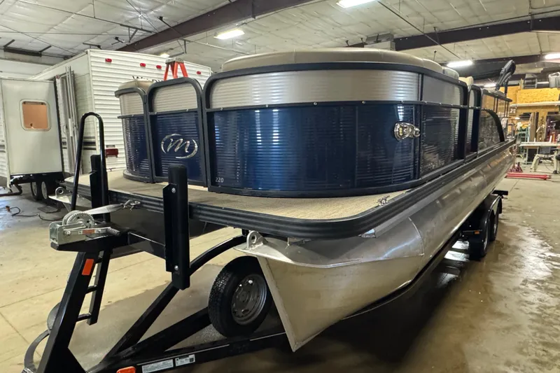 The Image of 2021 Manitou 22 Aurora LE Standard pontoon boat on trailer in warehouse. - 1