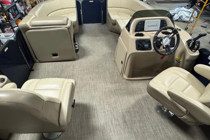 Slide: The Image of Interior of 2021 Manitou 22 Aurora LE Standard pontoon boat with beige seating and Garmin dashboard. - 16