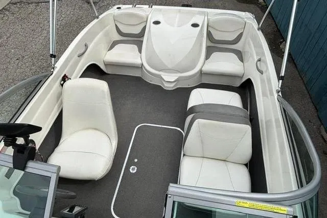 Slide: The Image of 2010 Bayliner 175 Bowrider interior with white seating and gray flooring. - 11