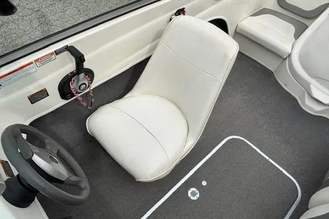 Slide: The Image of Interior of 2010 Bayliner 175 Bowrider boat with white seating and steering wheel. - 12