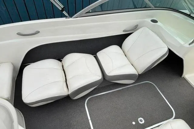 Slide: The Image of 2010 Bayliner 175 Bowrider interior with white cushioned seating and gray accents. - 18
