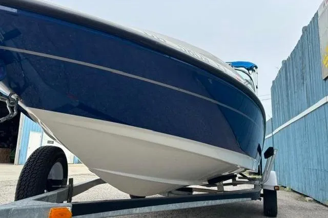 Slide: The Image of 2010 Bayliner 175 Bowrider on trailer, blue hull, parked outdoors. - 3