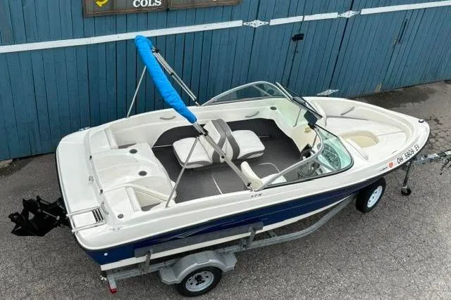 Slide: The Image of 2010 Bayliner 175 Bowrider on trailer, parked near blue garage doors. - 8