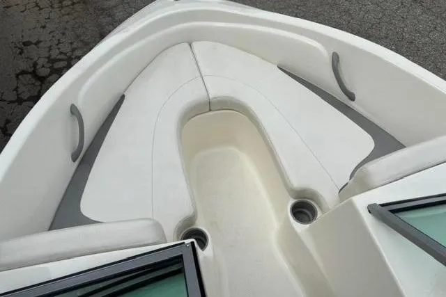 Slide: The Image of 2010 Bayliner 175 Bowrider boat interior with white seating and cup holders. - 9