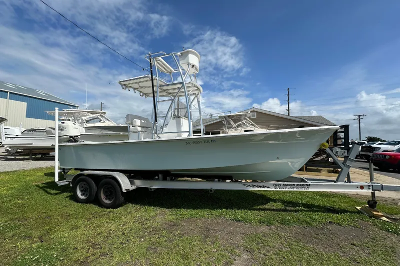 The Image of 2021 C-Hawk 23 Center Console boat on trailer at marina under blue sky. - 0