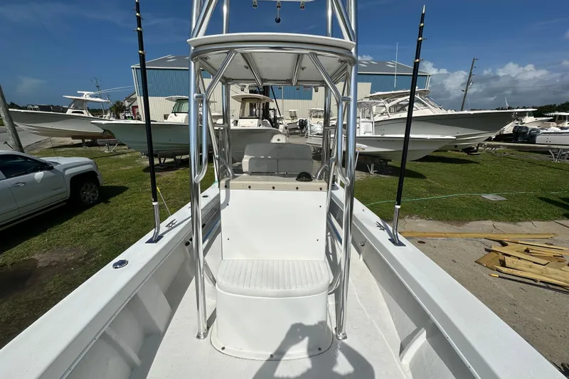 Slide: The Image of 2021 C-Hawk 23 Center Console boat with T-top, parked outdoors under clear skies. - 15