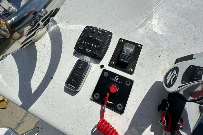 Slide: The Image of 2021 C-Hawk 23 Center Console boat controls with Suzuki emergency stop and trim tabs. - 18