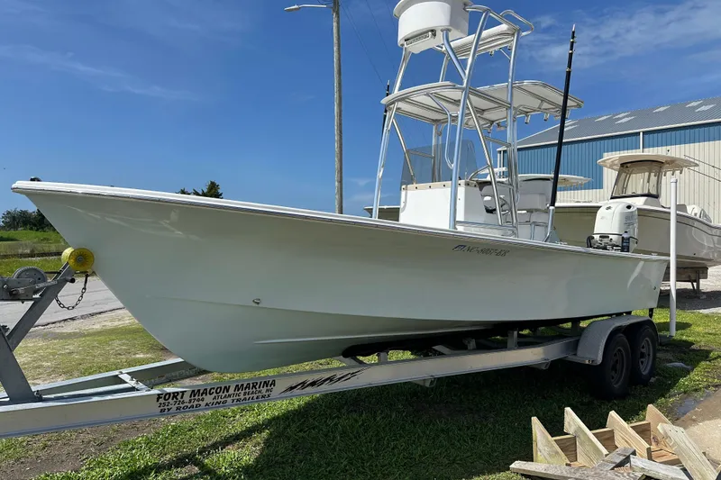 Slide: The Image of 2021 C-Hawk 23 Center Console boat on trailer at marina under clear blue sky. - 4