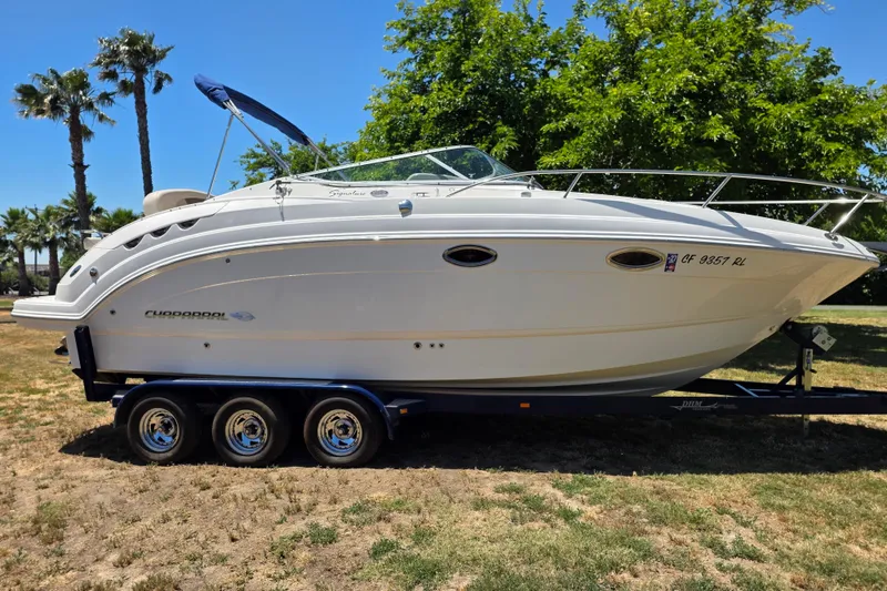 The Image of 2007 Chaparral Signature 250 boat on trailer, parked on grass with trees in background. - 0