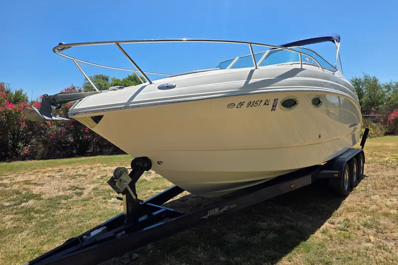 Slide: The Image of 2007 Chaparral Signature 250 boat on trailer, parked on grass under clear blue sky. - 2