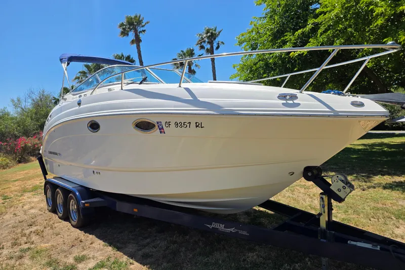 Slide: The Image of 2007 Chaparral Signature 250 boat on trailer, parked on grass with palm trees in background. - 3